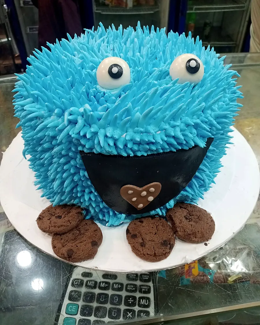 Blue Cookie Monster cake with cookies around it
