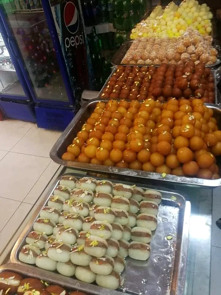 Trays of gulab jamun, chum chum and sweets in the Freshco display